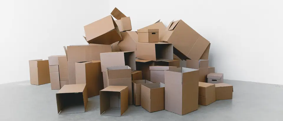 A pile of packed cartons on a pale floor in daylight