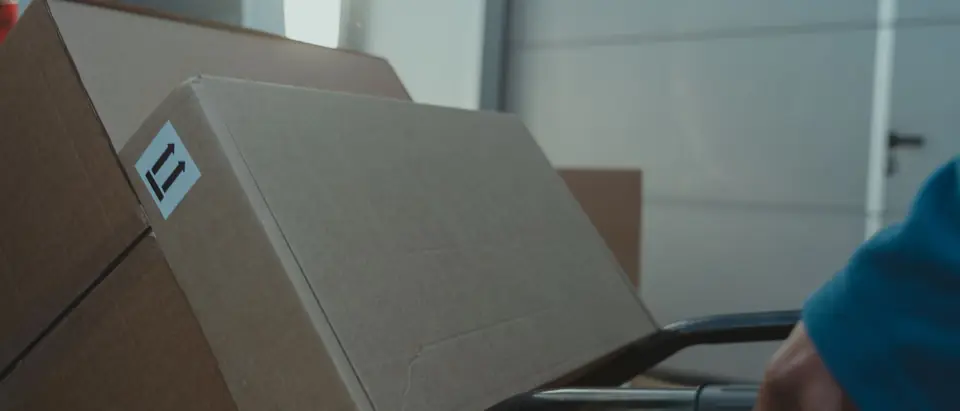 A carton on a hand trolley inside a van
